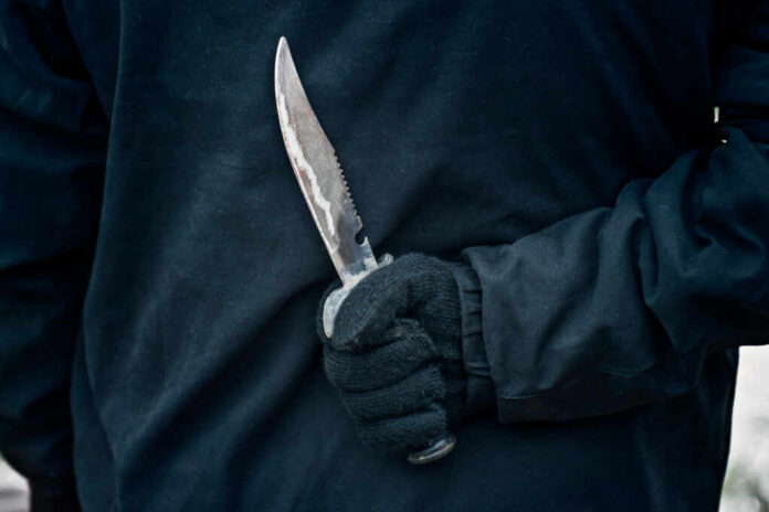 Man,With,The,Knife.,Hand,With,A,Knife,Behind,His