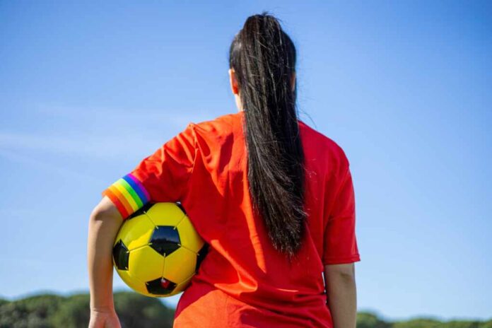Soccer,Player,Woman,With,A,Soccer,Ball,And,Captain,Armband