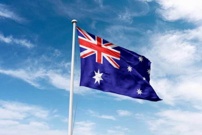 Australia,Flag,Waving,At,Cloudy,Sky,Background.,The,Commonwealth,Of