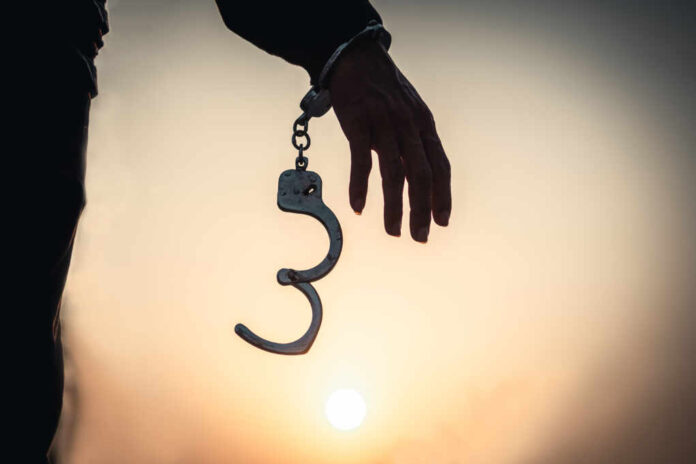 Business,Man,Holding,Handcuffs,After,Releasing,Over,Sunset,Background.,Freedom