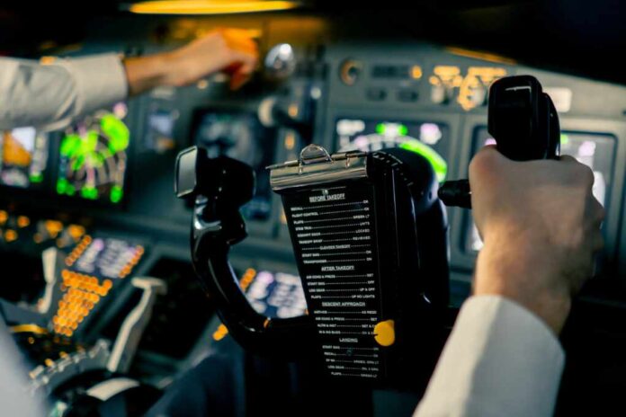 Close-up,Pilot,In,The,Cockpit,Of,An,Airplane,Holding,A