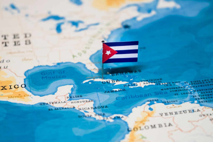 shutterstock_1326836042.jpg A small Cuban flag placed on a map highlighting Cuba in the Caribbean