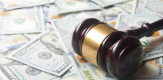 A gavel resting on a pile of hundred dollar bills