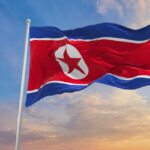 North Korea’s Missile Barrage SHOCKS the World North Korean flag waving against a blue sky