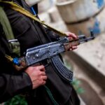 Taliban Gang Ties EXPOSED in Shocking Utah Attack Soldier holding an AK-47 rifle in a conflict area
