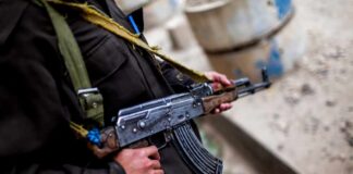 Soldier holding an AK-47 rifle in a conflict area