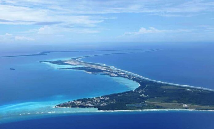 shutterstock_2353366637.jpg Aerial view of a tropical island surrounded by blue ocean waters