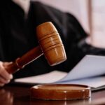 Judges Block Trump’s Law-Firm Clampdown A judges gavel poised above a wooden block with a document in the background