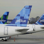 IT Meltdown: JetBlue’s Flights Frozen Three jetBlue aircraft tails lined up at an airport