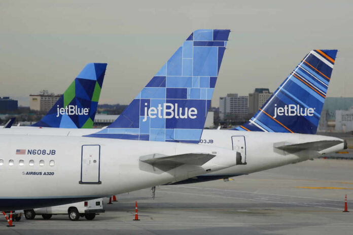 Three jetBlue aircraft tails lined up at an airport