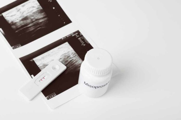 Ultrasound images and a bottle of misoprostol next to a pregnancy test