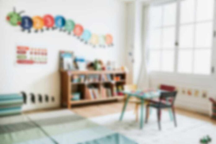 shutterstock_2533730441.jpg A bright and colorful children's room with a bookshelf and a play table