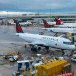 Airport Horror: 70 Injured in Fiery Collision Air Canada planes parked at an airport terminal with ground crew working