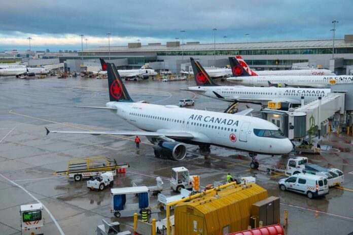 Air Canada planes parked at an airport terminal with ground crew working