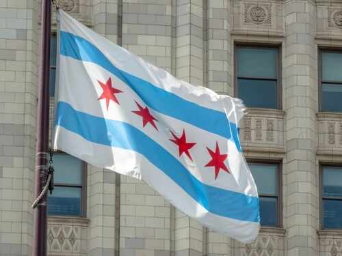 shutterstock_2678615209.jpg Chicago flag waving in front of a building