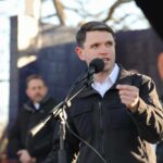 Individual speaking into a microphone at an outdoor event