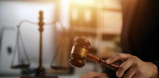 A gavel being struck on a desk in a courtroom setting