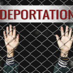 Hands reaching through a metal fence with the word DEPORTATION above