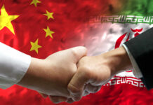 Handshake between two individuals with Chinese and Iranian flags in the background