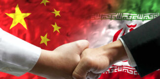 Handshake between two individuals with Chinese and Iranian flags in the background