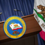 Podium with the seal of the Governor of California and state flag in the background