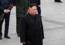 A political figure in formal attire participating in a solemn ceremony