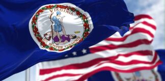 Virginia state flag waving in the foreground with an American flag in the background