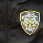 Close-up of a New York City Police Department badge on a black jacket
