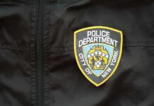 Close-up of a New York City Police Department badge on a black jacket