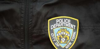 Close-up of a New York City Police Department badge on a black jacket