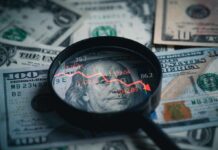 Market SHOCK: Trump’s Iran Post Flips Stocks Magnifying glass over US dollar bills with stock market data displayed