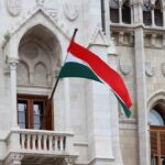 Hungarian flag waving in front of a historic building