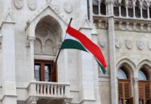 Hungarian flag waving in front of a historic building