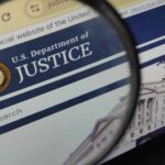 Close-up view of the U.S. Department of Justice website through a magnifying glass