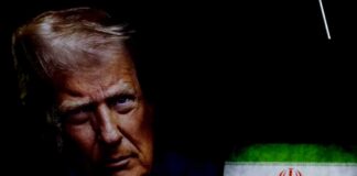 Close-up portrait of a political figure with an Iranian flag in the background