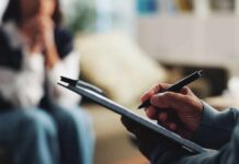 Political Sabotage: Is America Self-Destructing? A therapist taking notes during a session with a client in the background