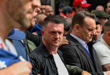 A group of individuals at a protest holding a banner