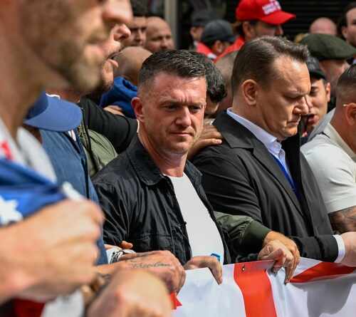 A group of individuals at a protest holding a banner