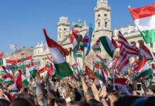 A large crowd waving Hungarian flags at a political rally