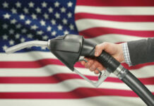 War Crisis: Indiana’s Gas Tax Axed! A hand holding a fuel pump in front of an American flag