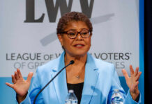 A female politician speaking passionately at a podium during a conference