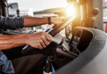 Massive Ban: No More Licenses for Illegal Immigrants Close-up of a truck driver's hands on the steering wheel inside a vehicle