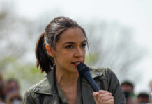 A woman speaking passionately into a microphone at an outdoor event