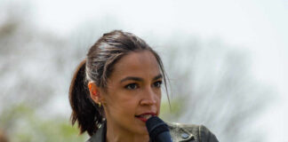 A woman speaking passionately into a microphone at an outdoor event