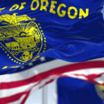 Oregon state flag waving in front of an American flag