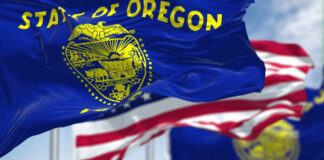 Controversial Law Threatens Oregon Traditions Oregon state flag waving in front of an American flag
