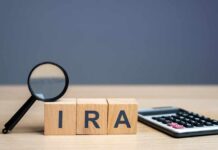 Magnifying glass and wooden blocks spelling 'IRA' next to a calculator