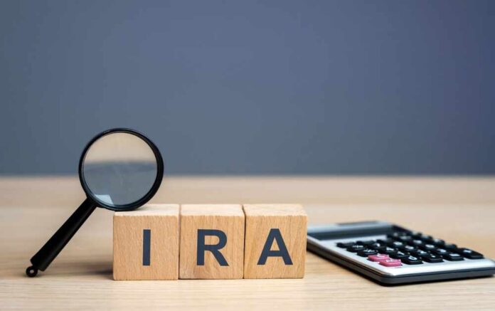 Magnifying glass and wooden blocks spelling 'IRA' next to a calculator