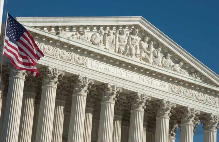 The,United,States,Supreme,Court,In,Washington,Dc United States Supreme Court facade with flag and Corinthian columns