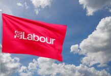 Red flag with 'Labour' logo waving against a cloudy sky